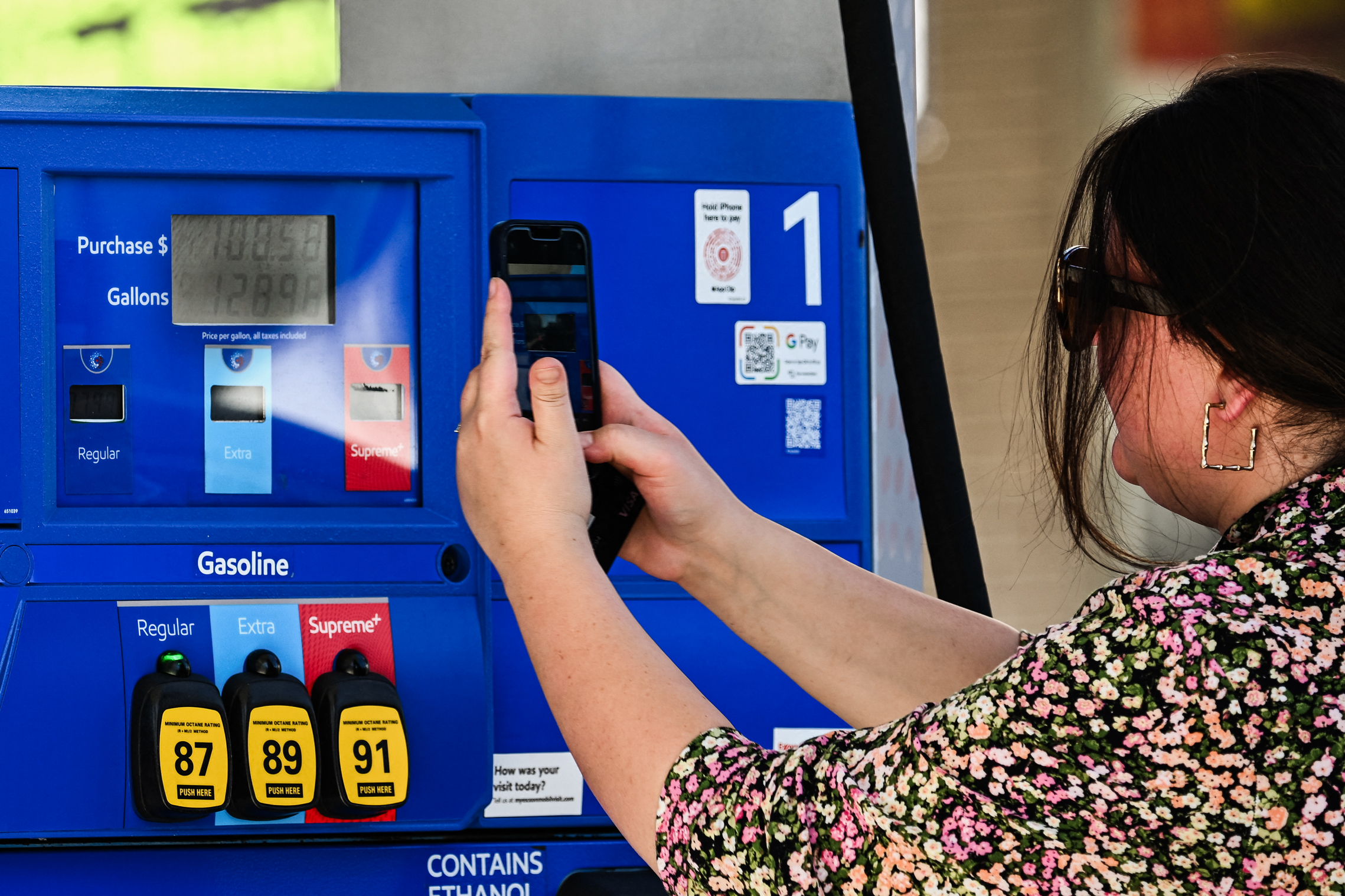 Một khách hàng chụp ảnh một máy bơm xăng sau khi đổ xăng tại một trạm xăng với giá hơn 7 USD một gallon tại trạm xăng Mobil ở Los Angeles hôm 05/10/2023. (Ảnh: Patrick T. Fallon/AFP qua Getty Images)