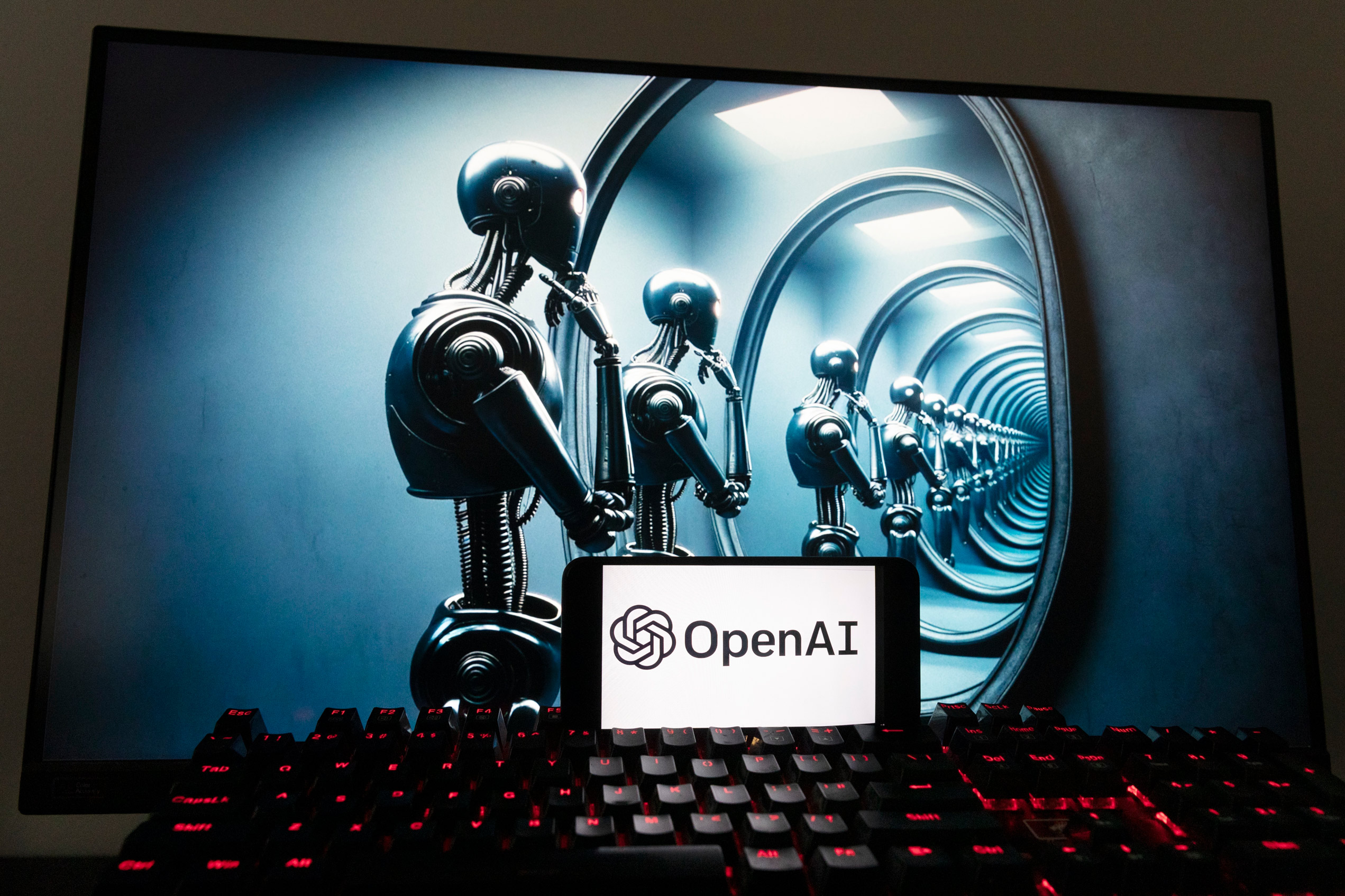 Logo OpenAI hiển thị trên điện thoại di động cùng với hình ảnh trên màn hình máy điện toán được tạo bởi mô hình chuyển văn bản thành hình ảnh Dall-E của ChatGPT ở Boston hôm 08/12/2023. (Ảnh: Michael Dwyer/AP Photo)
