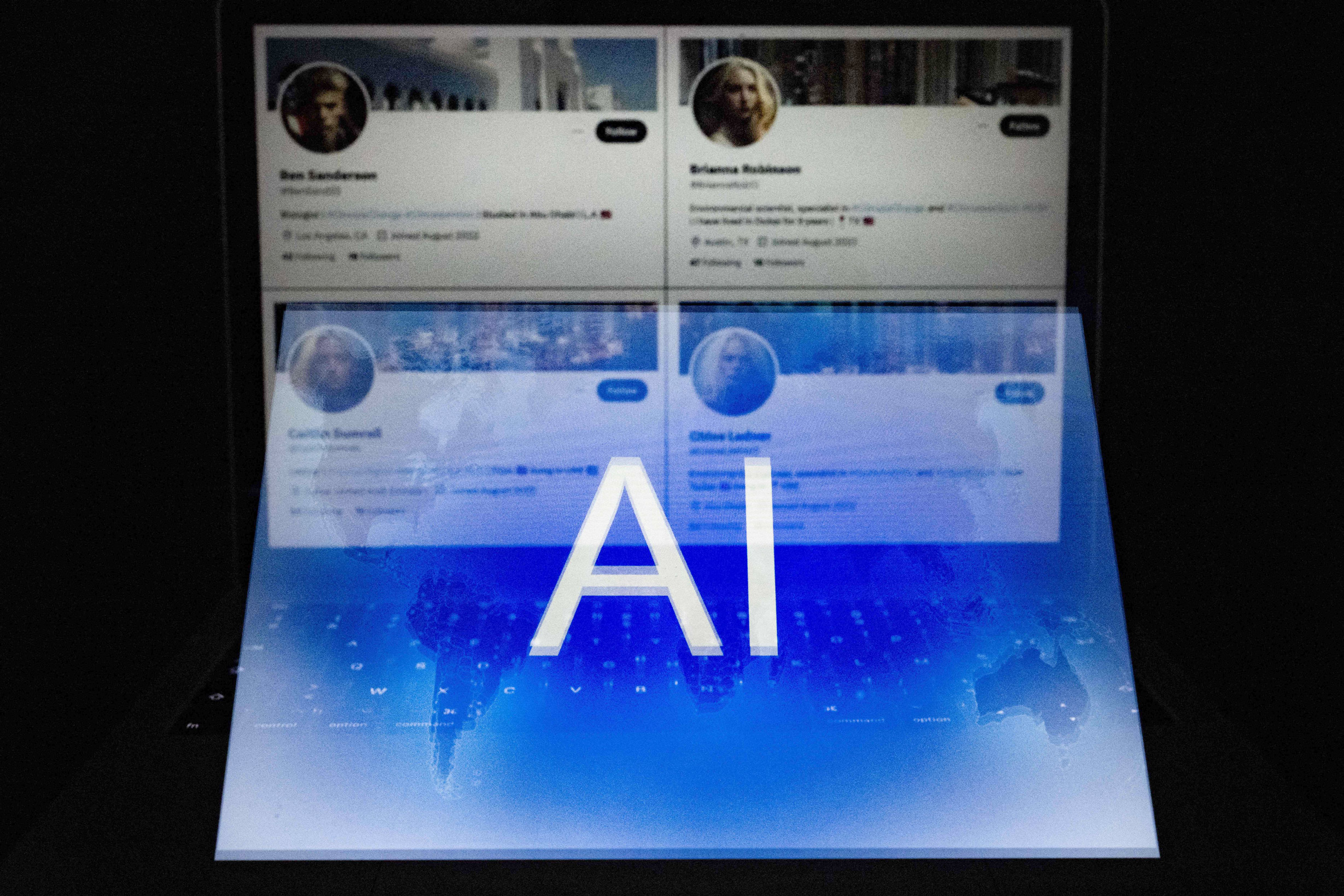 Một logo AI được lồng vào bốn trương mục Twitter giả có ảnh hồ sơ dường như do AI tạo ra, được chụp ở Helsinki, Phần Lan, vào ngày 12/06/2023. (Ảnh: Olivier Morin/AFP qua Getty Images)