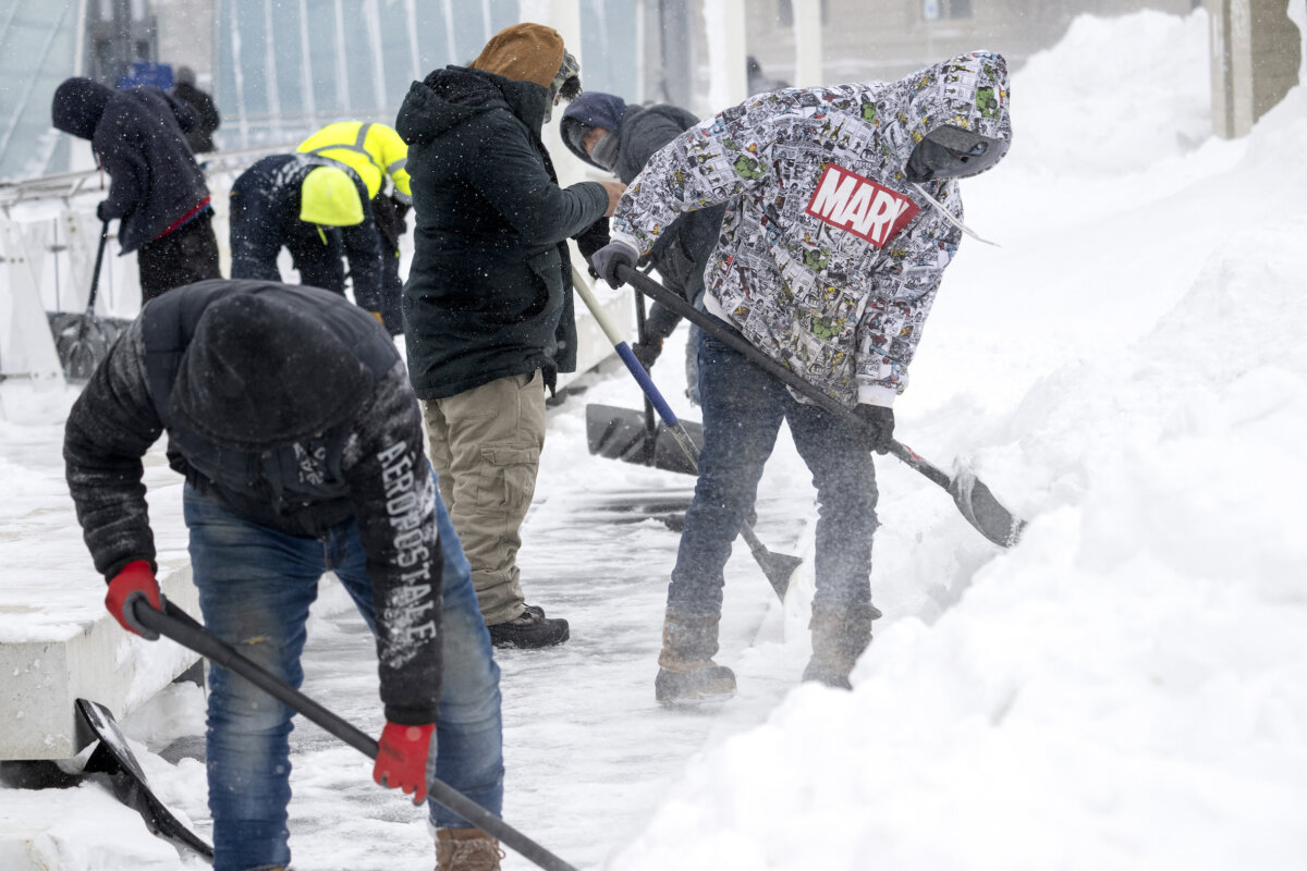 Các công nhân dọn tuyết trên vỉa hè ở Des Moines, Iowa, hôm 13/01/2024, giữa lúc thời tiết lạnh giá kỷ lục sẽ gây phức tạp cho các cuộc họp bầu ở Iowa. (Ảnh: Jim Watson/AFP)
