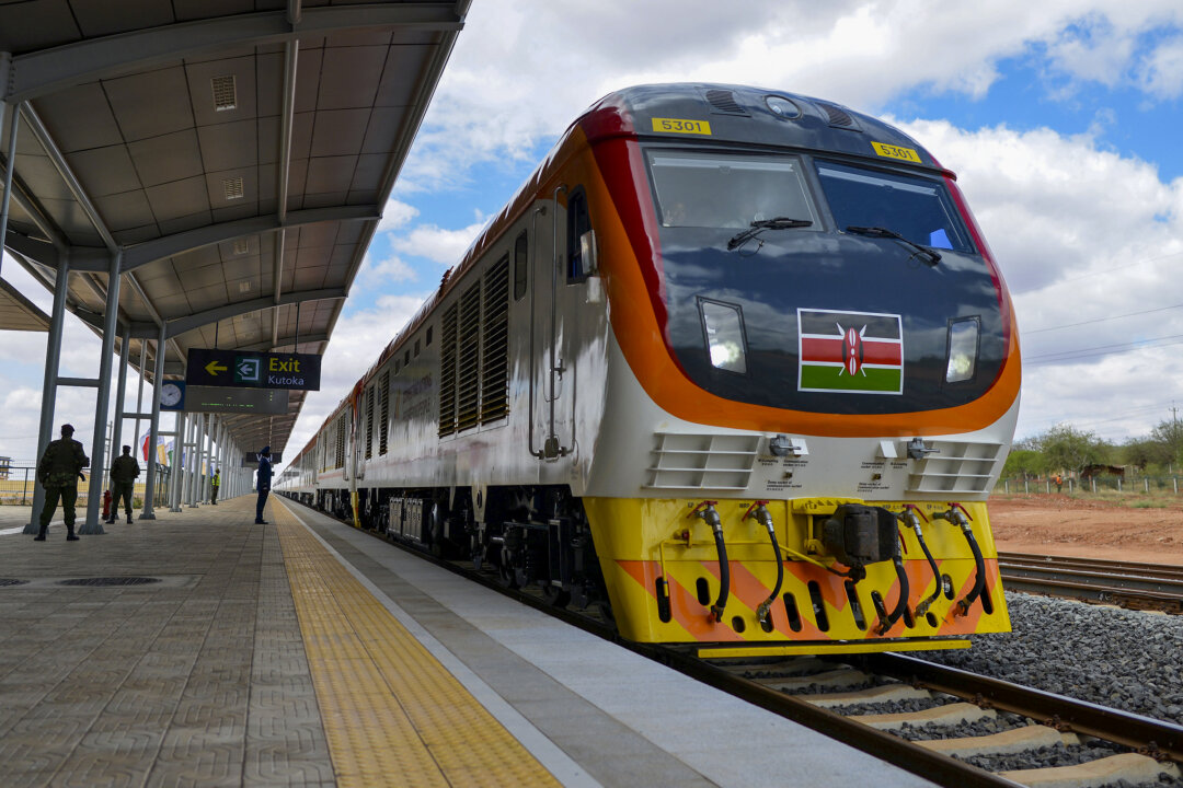 Một trong những đầu máy xe lửa khổ tiêu chuẩn mà Kenya mới mua được, chở Tổng thống Kenya tiến vào ga xe lửa Voi vào ngày 31/05/2017 tại Voi, trong một chuyến đi khánh thành tuyến đường sắt khổ tiêu chuẩn mới của Kenya từ thành phố duyên hải Mombasa đến thủ đô Nairobi. Hôm thứ Tư, Tổng thống Kenya Uhuru Kenyatta đã khánh thành tuyến đường sắt do Trung Quốc xây dựng, dự án cơ sở hạ tầng lớn nhất kể từ khi độc lập của đất nước này nhằm mục đích củng cố vai trò là cửa ngõ vào Đông Phi. (Ảnh: Tony Karumba/AFP qua Getty Images)