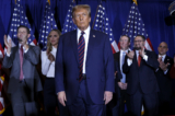 Ứng cử viên tổng thống bên Đảng Cộng Hòa, cựu Tổng thống Hoa Kỳ Donald Trump, lên sân khấu tranh biện cùng những người ủng hộ, nhân viên của chiến dịch và các thành viên gia đình trong bữa tiệc đêm bầu cử sơ bộ tại Sheraton ở Nashua, New Hampshire, hôm 23/01/2024. (Ảnh: Chip Somodevilla/Getty Images)