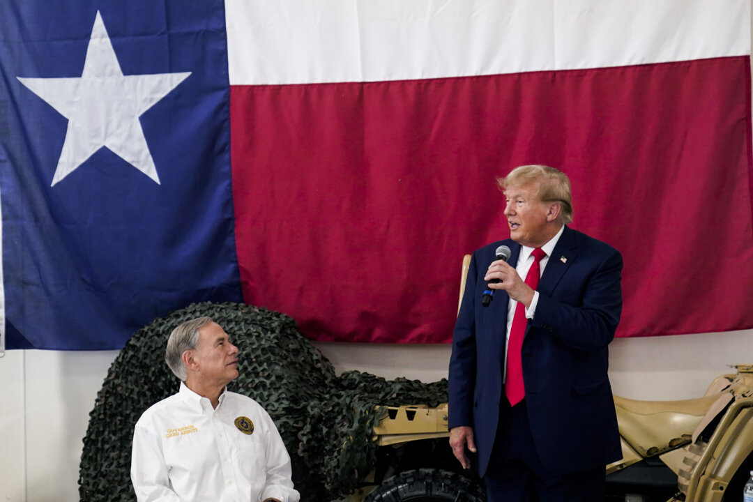 Thống đốc Texas Greg Abbott (bên trái) lắng nghe ứng cử viên tổng thống của Đảng Cộng Hòa — cựu Tổng thống Donald Trump (bên phải) — trò chuyện với quân đội và vệ binh của tiểu bang Texas trong bữa ăn Lễ Tạ Ơn tại Phi trường Quốc tế Nam Texas, hôm Chủ Nhật, ngày 19/11/2023, tại Edinburg, Texas. (Ảnh: AP Photo/Eric Gay)