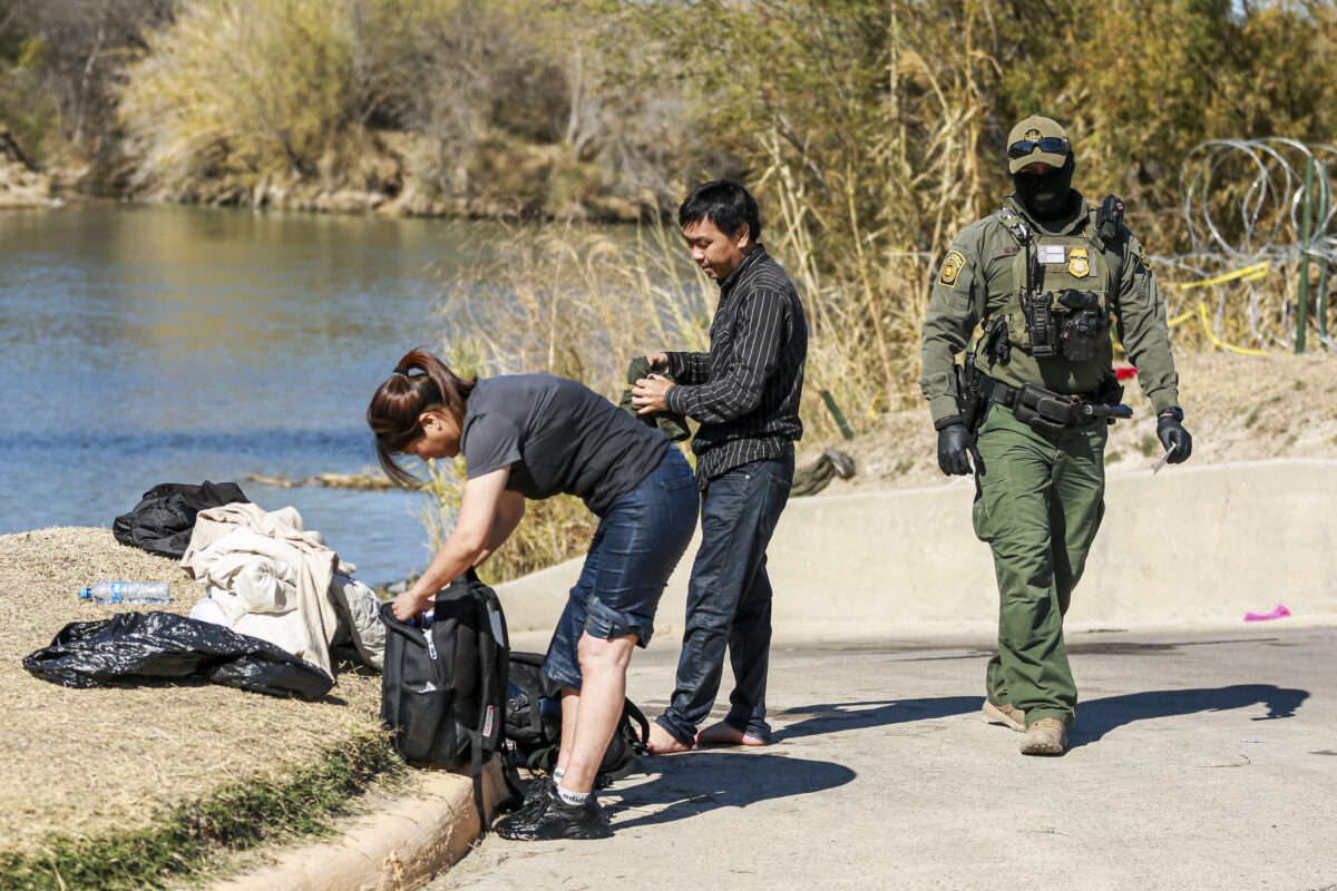 Một nhân viên Tuần tra Biên giới bắt giữ một cặp vợ chồng người Trung Quốc vừa lội qua sông Rio Grande từ phía Mexico vào Eagle Pass, Texas, vào ngày 25/01/2022. (Ảnh: Charlotte Cuthbertson/The Epoch Times)