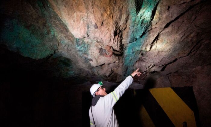 Một nhà địa chất chỉ ra nơi có quặng monazite (vùng có đá sẫm màu hơn) chứa khoáng chất đất hiếm ở mỏ SKK, cách thị trấn Vanrhynsdorp, Nam Phi, khoảng 50 dặm, vào hôm 29/07/2019. (Ảnh: Rodger Bosch/AFP qua Getty Images)