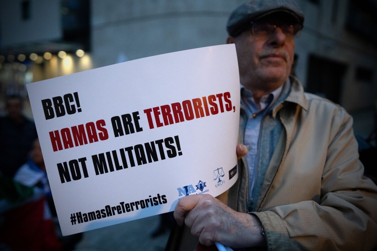 Một thành viên của cộng đồng Do Thái cầm tấm áp phích bên ngoài tòa nhà BBC Broadcasting House để biểu tình phản đối việc BBC từ chối gọi Hamas là những kẻ khủng bố, tại London, Anh quốc, vào ngày 16/10/2023. (Ảnh: Carl Court/Getty Images)