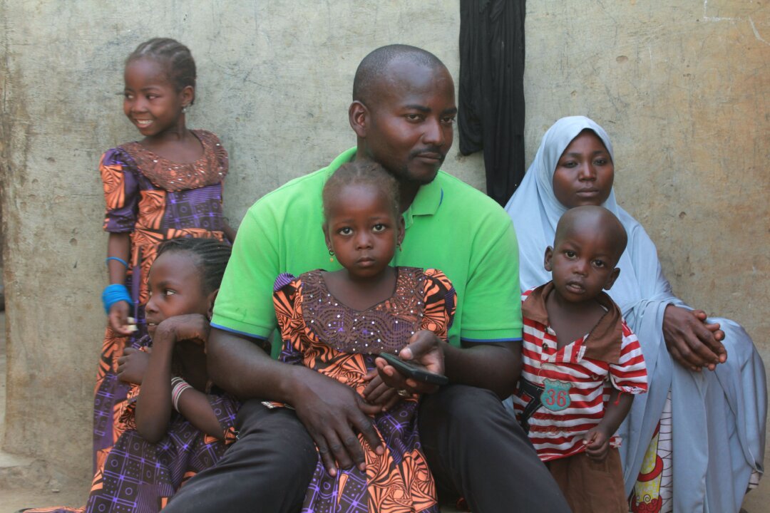 Ông Musa Maina, cha của một trong 110 nữ sinh bị nhóm khủng bố Boko Haram bắt cóc năm 2018, ngồi cùng gia đình ở Chibok, Nigeria, hôm 12/04/2019. Năm 2014, hơn 200 nữ sinh khác đã bị bắt đi. (Ảnh: Audu Ali Marte/AFP/Getty Images)