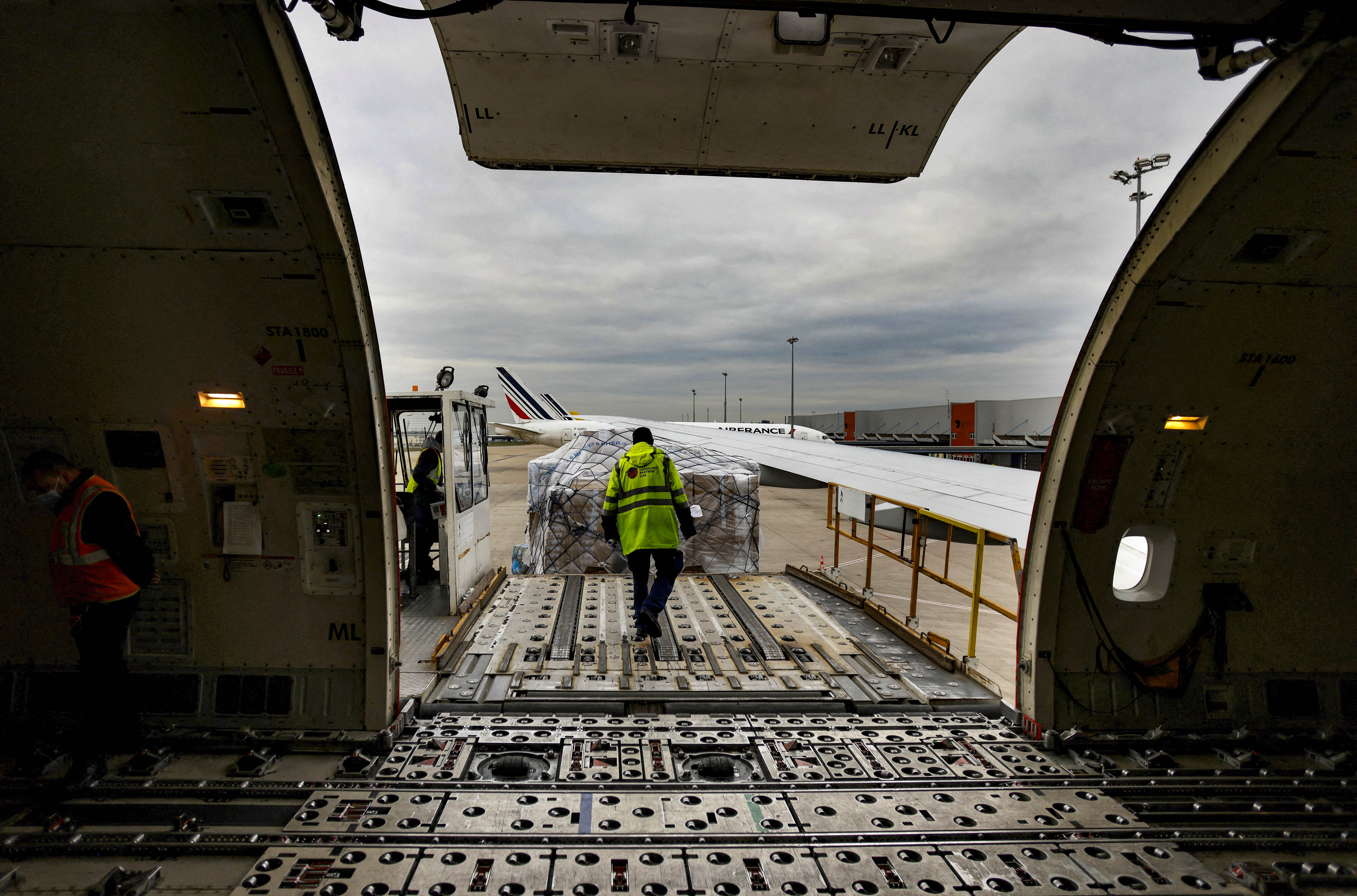 Nhân viên chuyển một container dược phẩm lên phi cơ chở hàng của Air France tại phi trường Roissy, phía bắc Paris, vào ngày 25/11/2020. (Ảnh: Thomas Coex/AFP qua Getty Images)