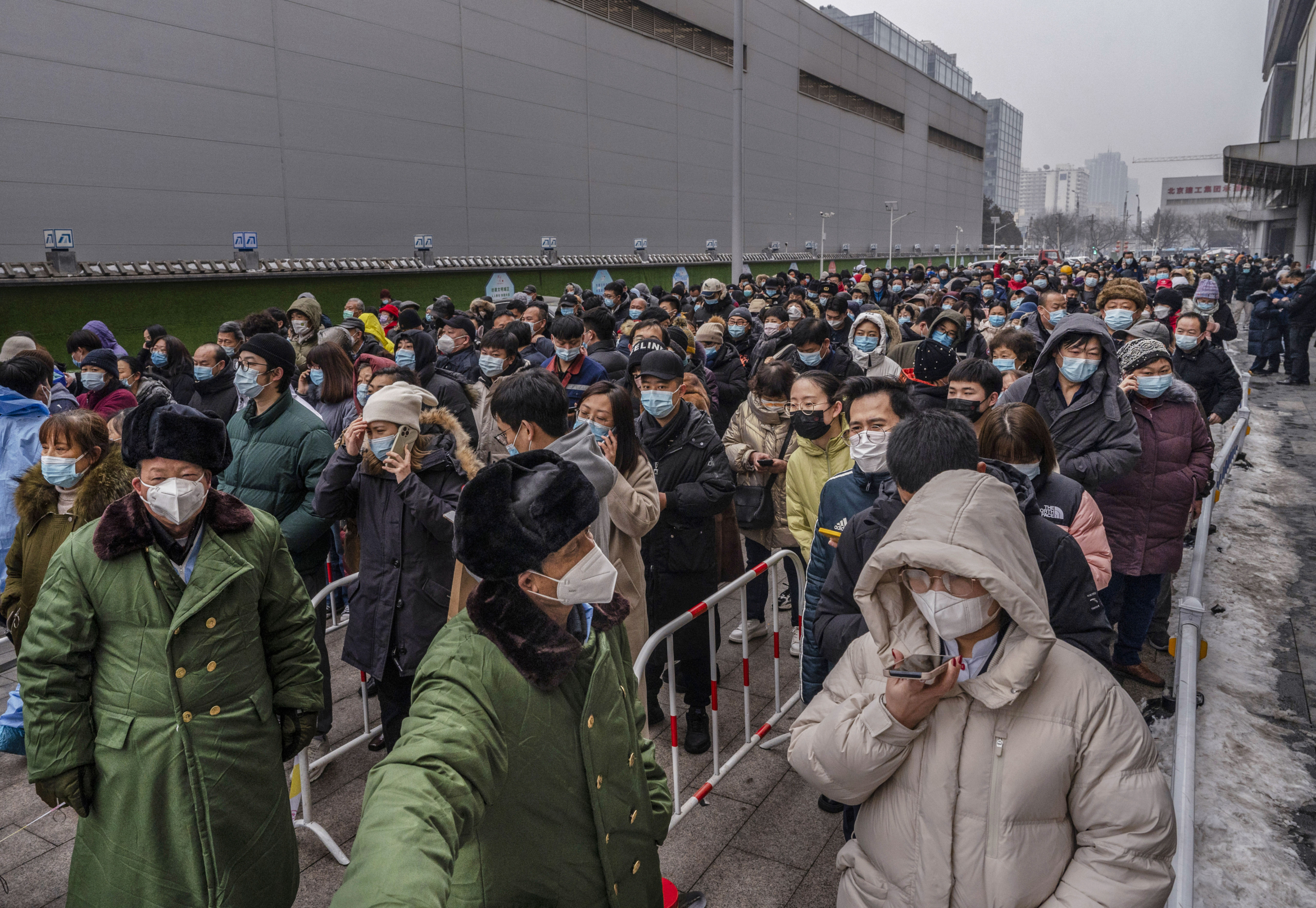 Các nhân viên an ninh đứng trước hàng dài người chờ xét nghiệm COVID-19 tại một địa điểm xét nghiệm hàng loạt ở Bắc Kinh, vào ngày 24/01/2022. (Ảnh: Kevin Frayer/Getty Images)