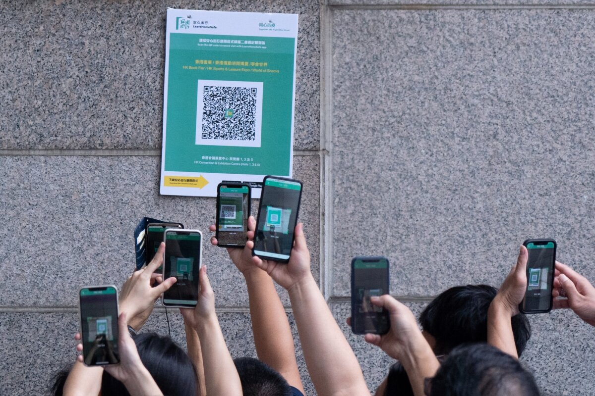 Người dân quét mã QR của một ứng dụng của chính phủ Hồng Kông để tìm người trong đợt bùng phát COVID-19 ở Hồng Kông vào ngày 17/07/2021. (Ảnh: Bertha Wang/AFP qua Getty Images)