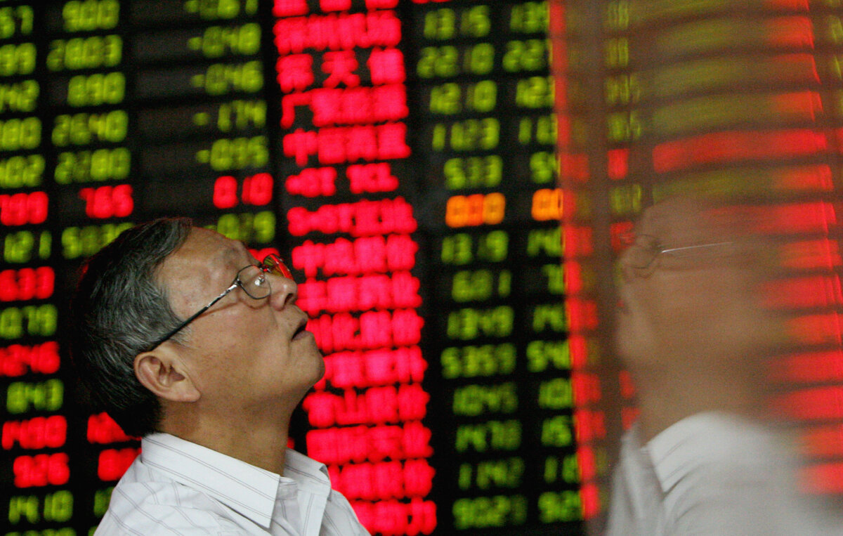 Một nhà đầu tư đứng cạnh bảng giá cổ phiếu cho thấy giá cổ phiếu đang giảm tại một công ty chứng khoán tư nhân ở Thượng Hải, ngày 22/10/2007. (Ảnh: Mark Ralston/AFP qua Getty Images)