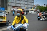 Một tài xế giao đồ ăn đeo khẩu trang đi xe đạp điện lái xe qua đường ở Bắc Kinh vào ngày 19/06/2020. (Ảnh: Wang Zhao/AFP qua Getty Images)