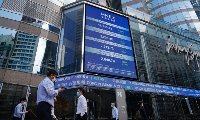 Người dân đi ngang qua màn hình hiển thị chỉ số chứng khoán Hang Seng tại khu Trung Hoàn, Hồng Kông, Trung Quốc, hôm 25/10/2022. (Ảnh: Lam Yik/Reuters)