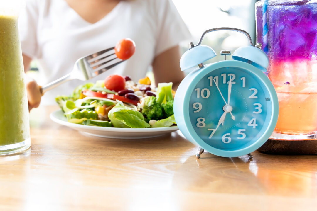 Đồng hồ màu xanh lam tượng trưng cho việc nhịn ăn gián đoạn cùng với món salad lành mạnh. (Ảnh: Nok Lek Travel Lifestyle/Shutterstock)