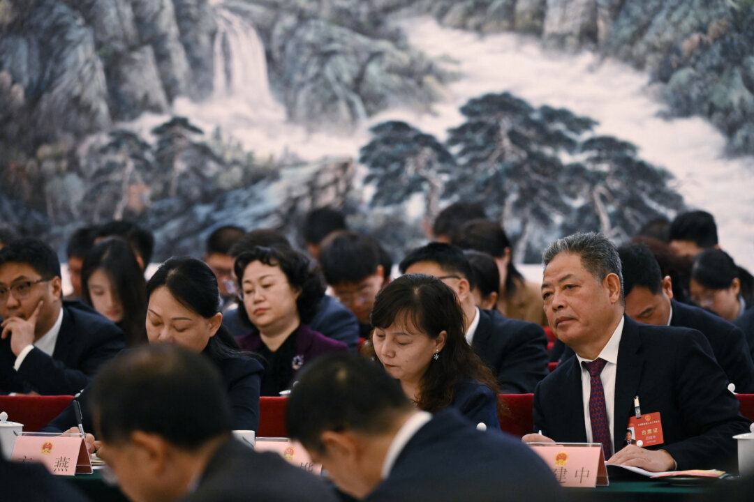 Các quan chức lắng nghe các bài diễn văn trong cuộc họp của phái đoàn Thiểm Tây trong kỳ họp Lưỡng hội thường niên tại Đại lễ đường Nhân dân ở Bắc Kinh, hôm 06/03/2024. (Ảnh: Greg Baker/AFP/Getty Images)