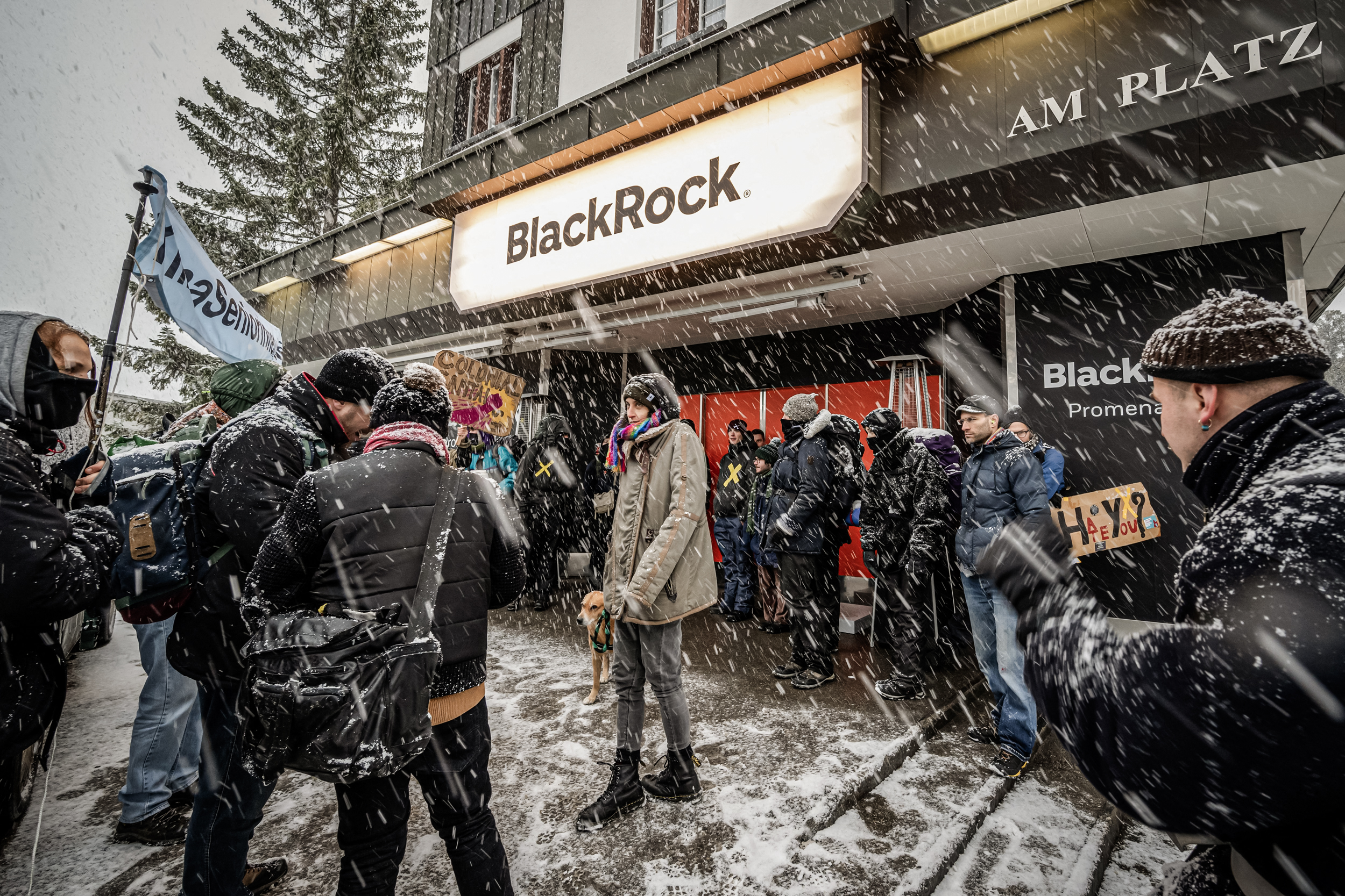 (Ảnh trên bên trái) Ông Larry Fink, Giám đốc điều hành của Blackrock, tham dự một cuộc thảo luận bàn tròn thúc đẩy quá trình chuyển đổi năng lượng toàn cầu tại hội nghị khí hậu của Liên Hiệp Quốc ở Dubai ngày 04/12/2023. (Ảnh trên bên phải) Người dân đi ngang qua Sở Giao dịch Chứng khoán New York ngày 19/01/2024. (Ảnh dưới) Các nhà hoạt động của Hiệp hội Thanh niên Xã hội Chủ nghĩa Thụy Sĩ phản đối BlackRock trước thềm cuộc họp WEF ở Davos, ngày 15/01/2022. (Ảnh: Sean Gallup/Getty Images, Spencer Platt/Getty Images, Fabrice Coffrini/AFP qua Getty Images)
