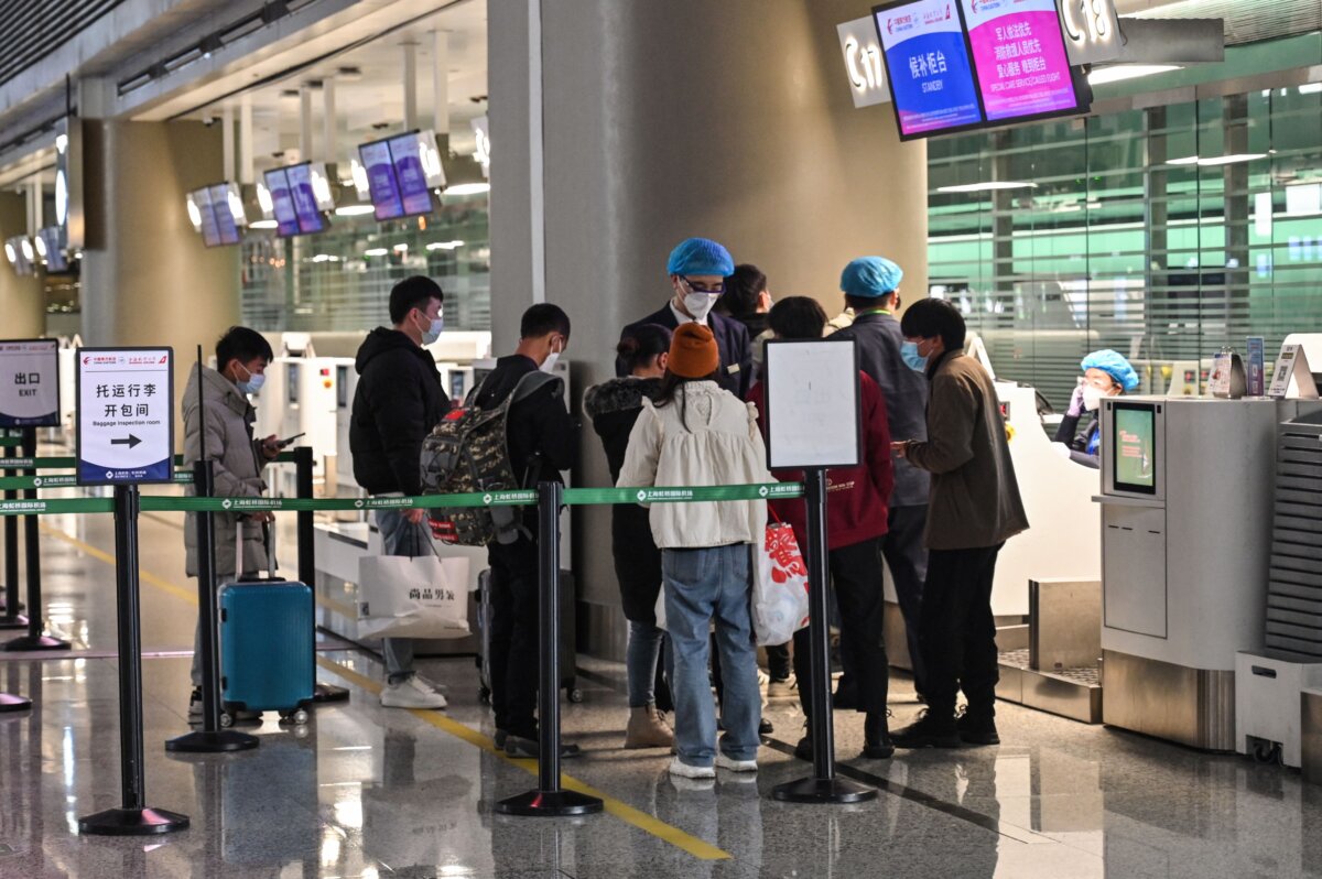 Mọi người đứng tại quầy làm thủ tục check-in của hãng hàng không China Eastern Airlines tại Phi trường Quốc tế Hồng Kiều ở Thượng Hải vào ngày 21/03/2022. (Ảnh: Hector Retamal/AFP qua Getty Images)