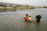 Những người nhập cư bất hợp pháp lội qua sông Rio Grande khi họ băng qua biên giới Hoa Kỳ - Mexico để xin tị nạn ở El Paso, Texas, hôm 13/03/2024. (Ảnh: John Moore/Getty Images)