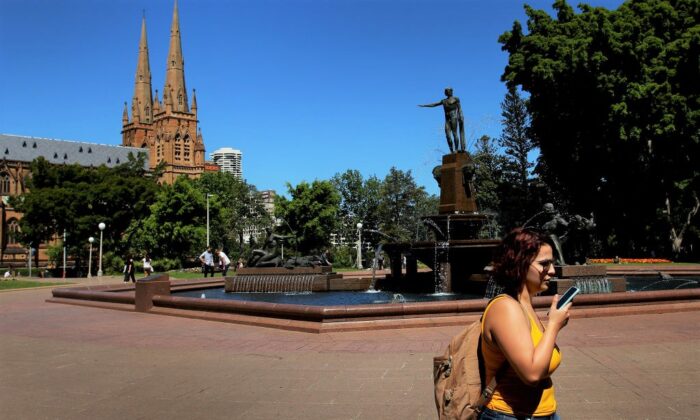 Một người phụ nữ nói chuyện điện thoại khi đi bộ qua Công viên Hyde ở Sydney, Úc, vào ngày 22/10/2019. (Ảnh: Lisa Maree Williams/Getty Images)