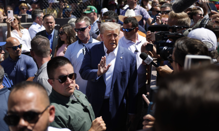 Cựu Tổng thống Trump, xung quanh là các nhân viên chiến dịch tranh cử và mật vụ, vẫy tay chào những người ủng hộ của ông khi ông đến thăm Cơ sở Sản xuất Thịt heo Iowa tại Hội chợ Tiểu bang Iowa ở Des Moines, Iowa, ngày 12/08/2023. (Ảnh: Chip Somodevilla/Getty Images)