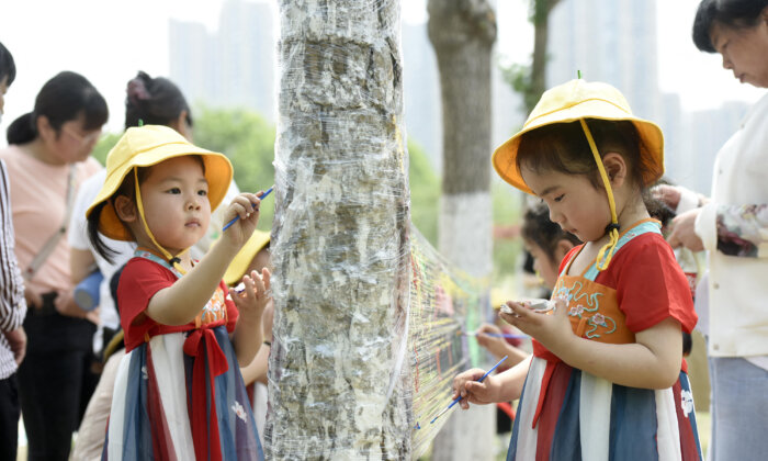 Trẻ em vẽ trên tấm nilon tại một công viên vào Ngày Quốc tế Thiếu nhi ở Hải An, Giang Tô, miền đông Trung Quốc, vào ngày 01/06/2022 (Ảnh: STR/AFP qua Getty Images)