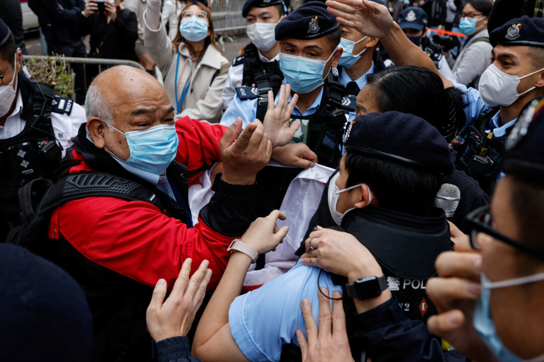 Một người ủng hộ xô xát với cảnh sát tại tòa nhà Tòa án Sơ thẩm Tây Cửu Long trong phiên điều trần 47 nhà hoạt động ủng hộ dân chủ bị buộc tội âm mưu lật đổ theo luật an ninh quốc gia, tại Hồng Kông, vào ngày 06/02/2023. (Ảnh: Tyrone Siu/Reuters)