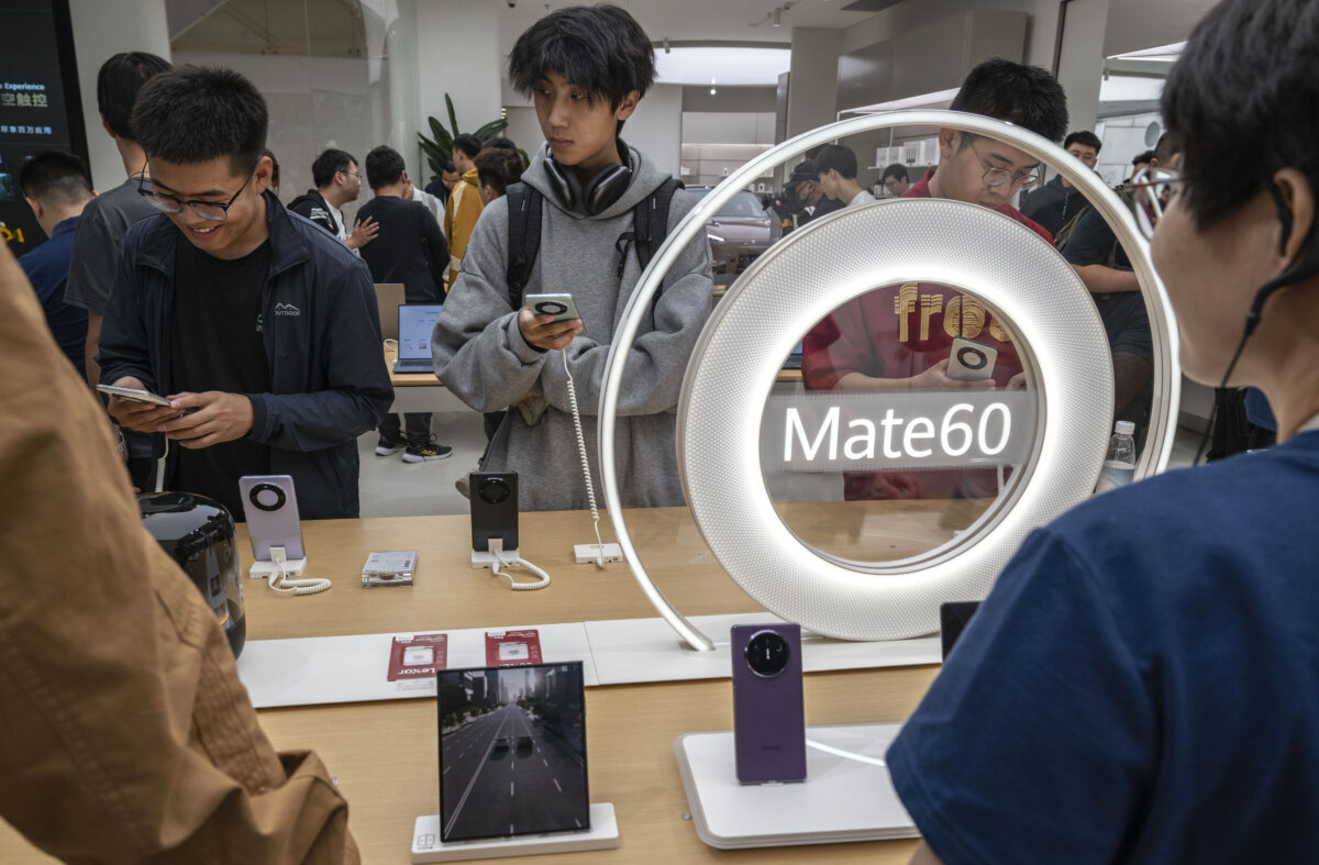 Mọi người ngắm nhìn những chiếc điện thoại thông minh mới ra mắt tại một cửa hàng hàng đầu của Huawei ở Bắc Kinh, Trung Quốc hôm 25/09/023. (Ảnh: Kevin Frayer/Getty Images)