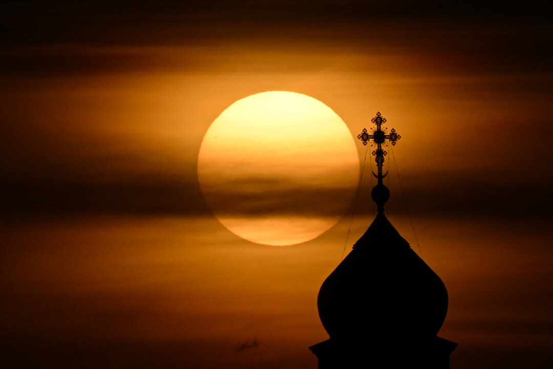 Mặt trời lặn sau mái vòm của nhà thờ Chúa Cứu Thế, nhà thờ Chính thống Nga, ở trung tâm thành phố Moscow vào ngày 25/10/2022. (Ảnh: Natalia Kolesnikova/AFP qua Getty Images)