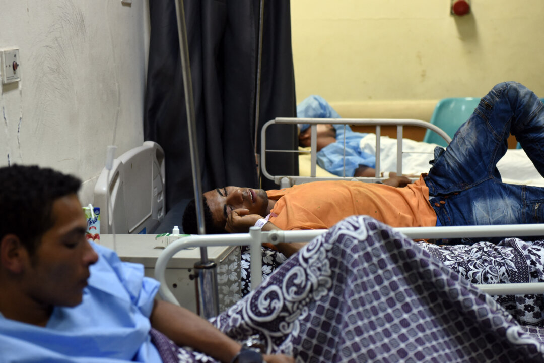 Người nhập cư được giải cứu Wael Mahmoud Mohammed (giữa), nằm trên giường cùng những người sống sót khác tại Bệnh viện Rashid ở Rosetta, miền bắc Ai Cập, vào ngày 21/09/2016, sau khi một chiếc thuyền bị lật ở Địa Trung Hải ngoài khơi bờ biển phía bắc Ai Cập, khiến 42 người thiệt mạng. (Ảnh: Mohamed El-Shahed/AFP qua Getty Images)