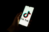 Một người cầm điện thoại thông minh với màn hình hiển thị logo của nền tảng truyền thông xã hội Trung Quốc TikTok, tháng 04/2024. (Ảnh: Antonin UTZ/AFP)